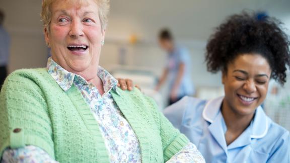 A patient and nurse laughing.