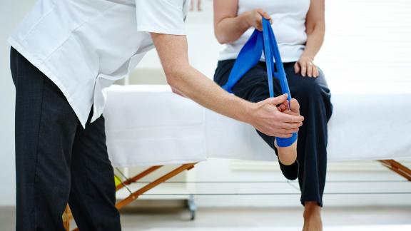 A physiotherapist checking a patient's leg.