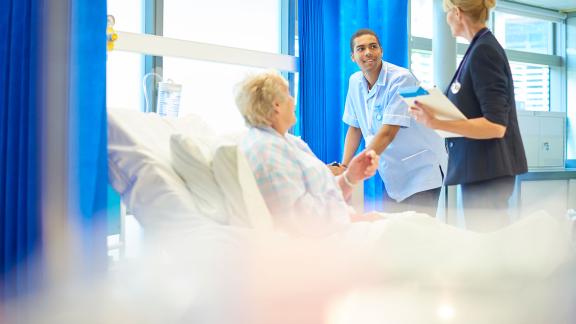 A nurse and doctor consulting a patient.