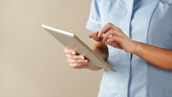 Close up of a nurse using a tablet.