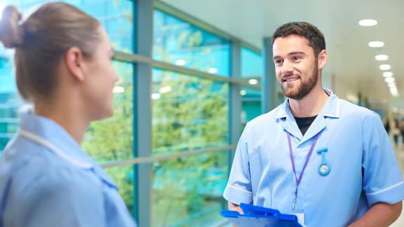 Student nurses talking in a corridor.