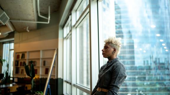 An office worker leaning on a window.