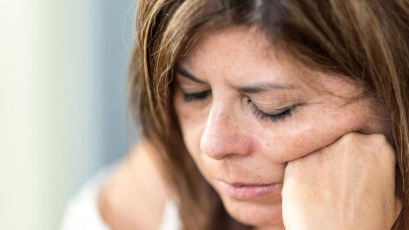 A woman resting her head on her hands.