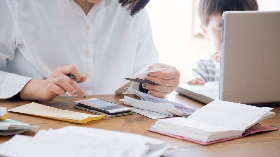 A person using a calculator and receipts to budget.