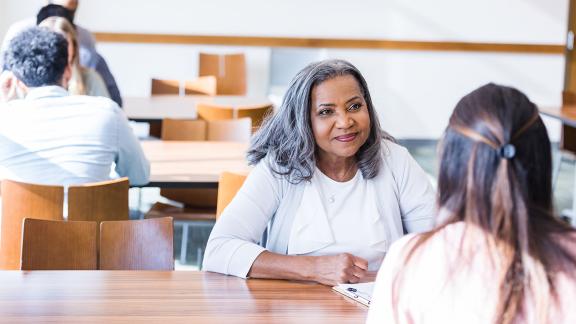 Two colleagues meeting in a canteen.