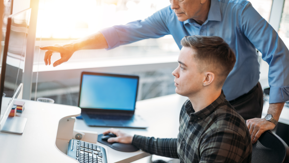 Two men looking at a computer screen