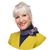Portrait of Hazel Wyton wearing a bright yellow jacket and patterned scarf