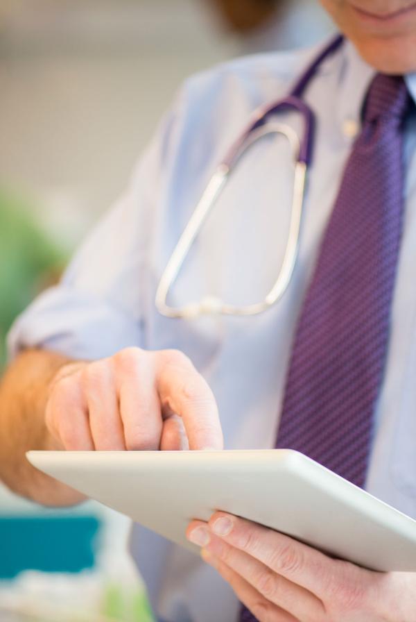 A doctor checking a tablet.