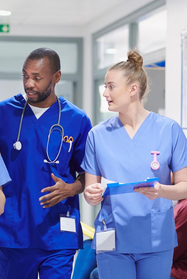 A diverse group of healthcare staff walking along a hospital corridor.