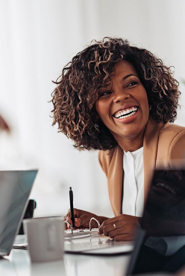 An office worker laughing during a meeting.