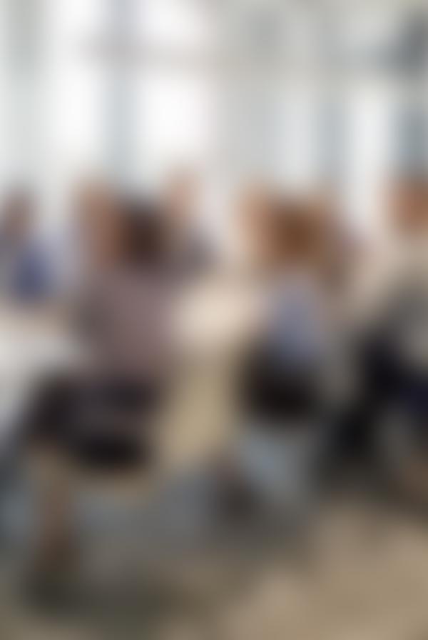 A blurred photograph of a meeting.