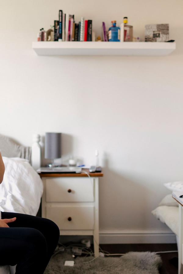 A medical student in their bedroom, talking on the phone.