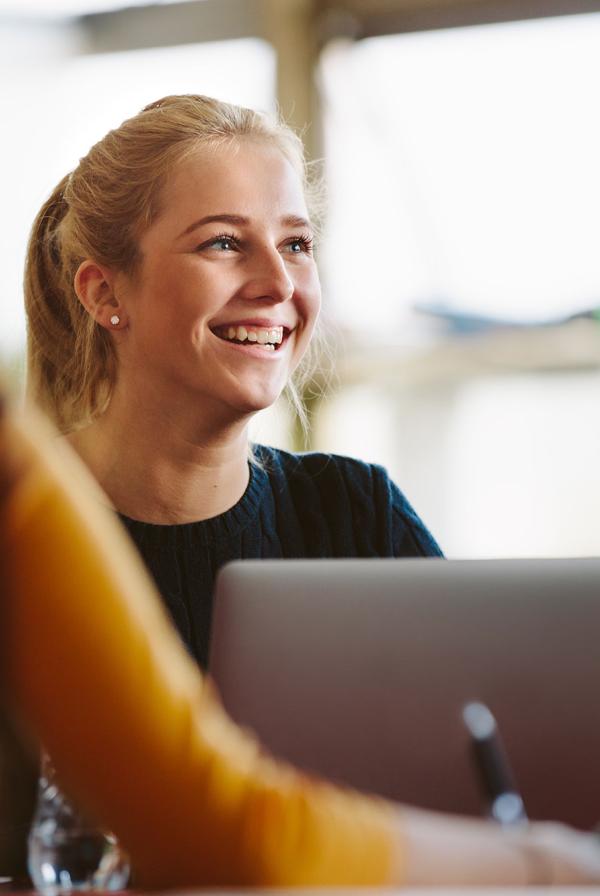 A young person smiling during a meeting.