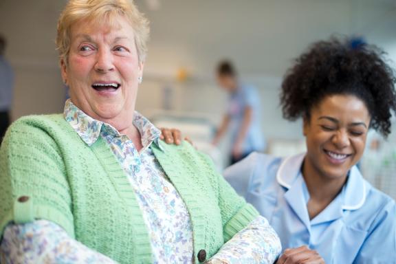 A patient and nurse laughing.