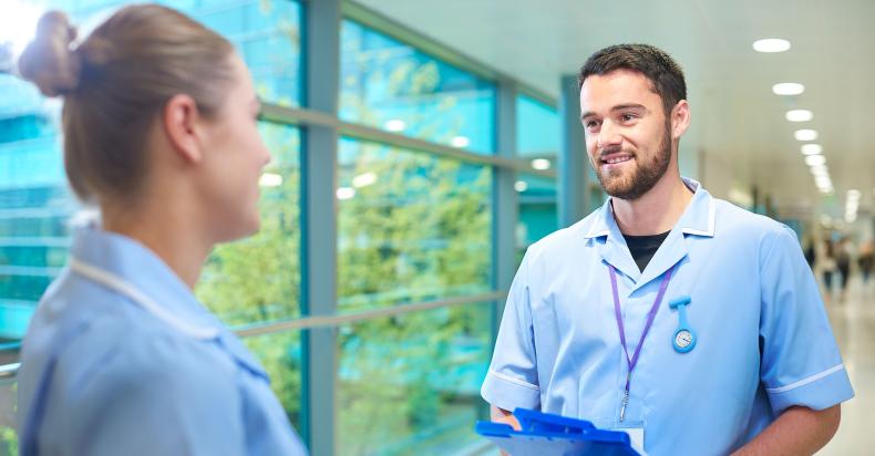 Student nurses talking in a corridor.