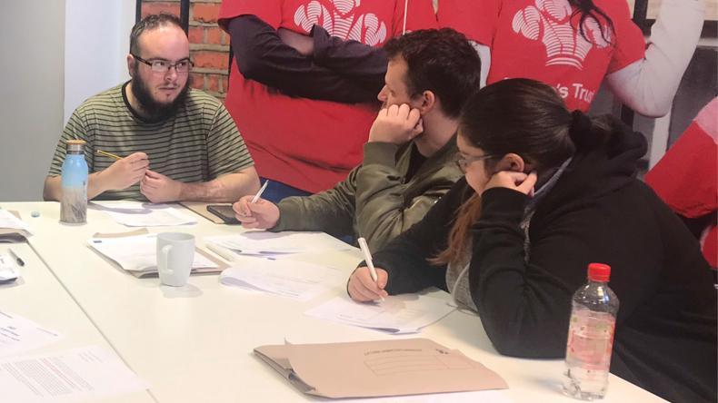 A group of young individuals working at a table collaboratively.