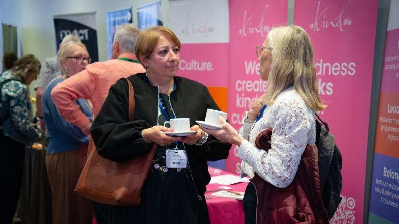 Two delegates chatting in a conference exhibition area